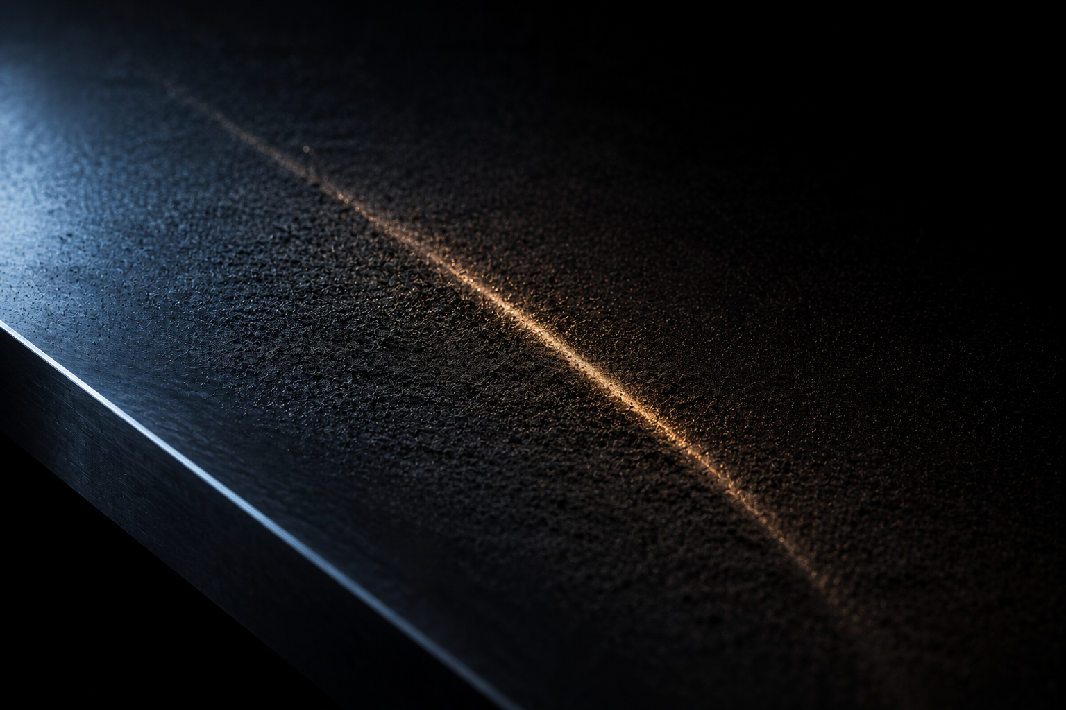 A thin layer of fine dark dust settled on polished steel, one single track through it