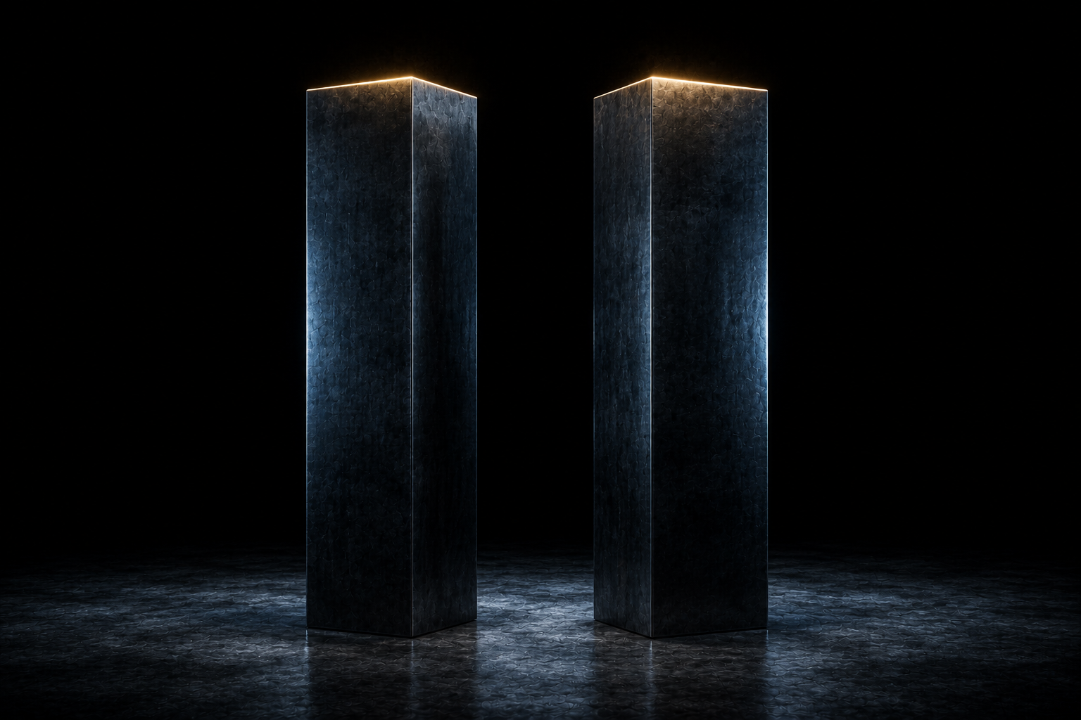 Two dark steel columns standing side by side, their top faces lit warm above everything around them