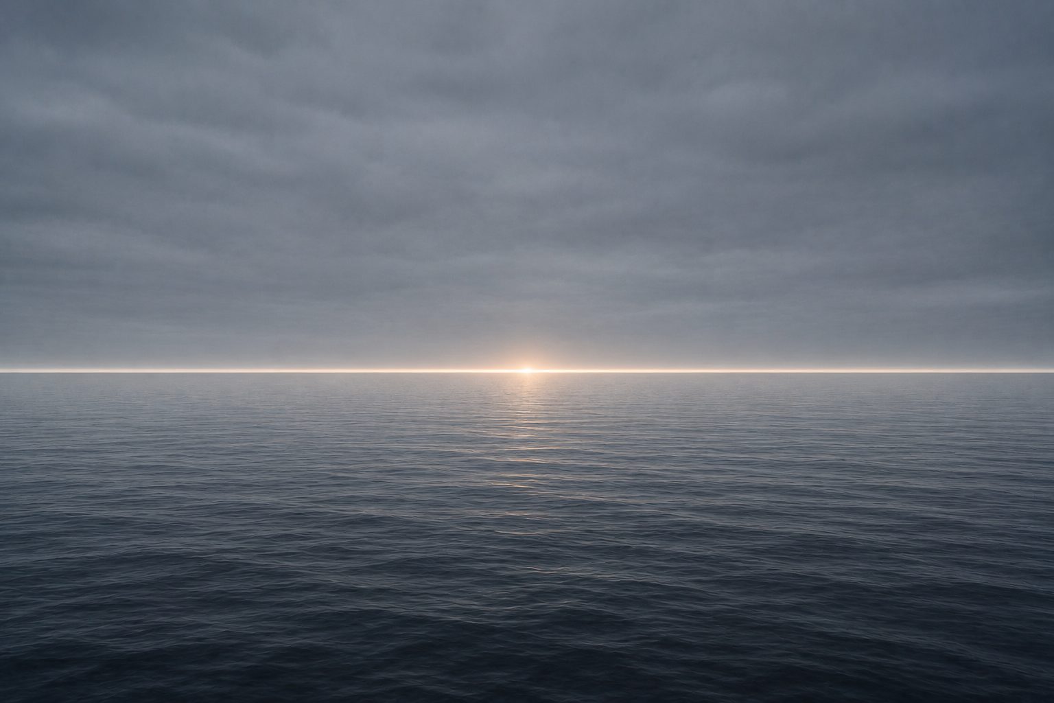 A calm sea meeting a flat grey sky, a single thin band of light marking the horizon