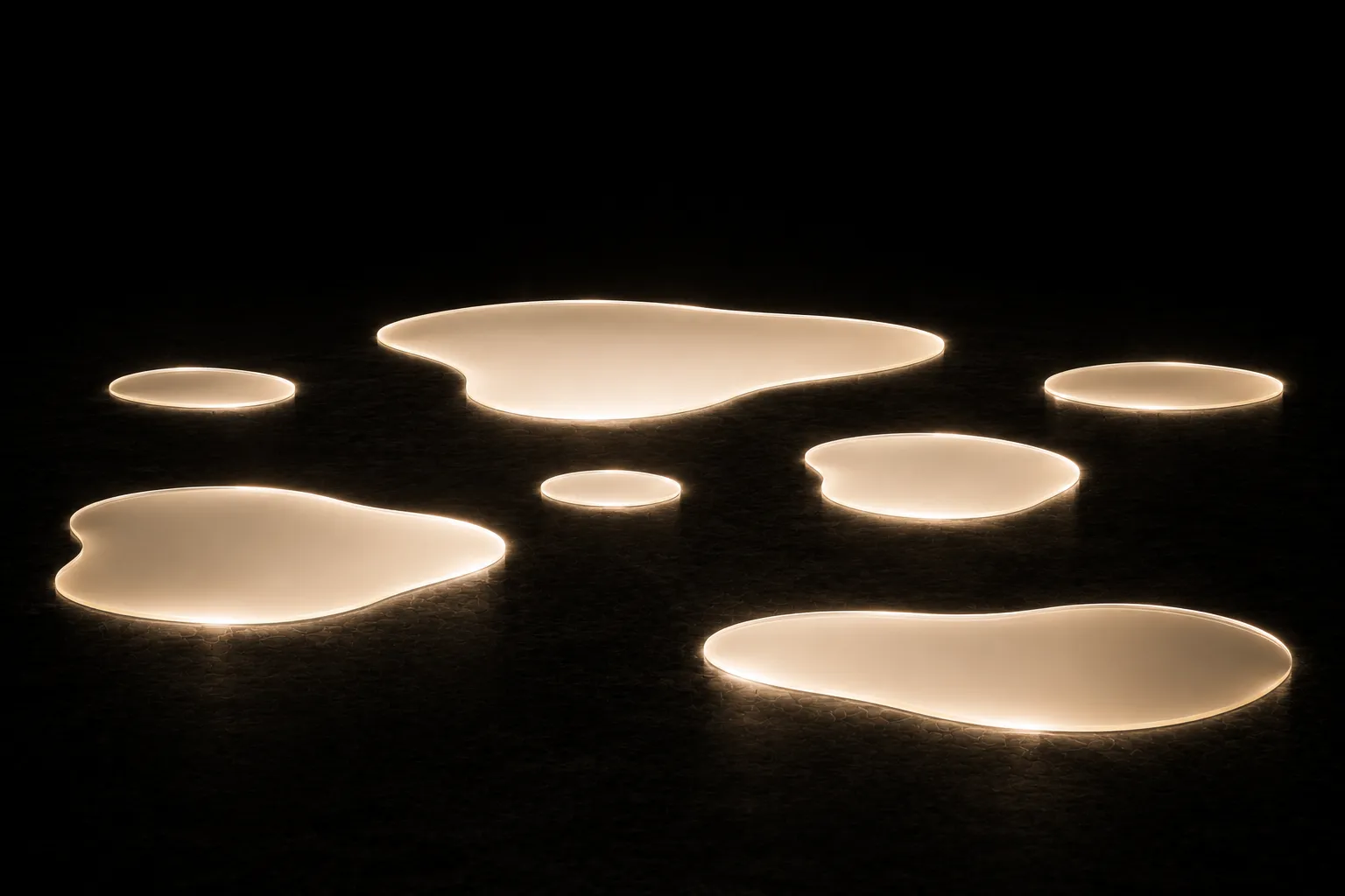 Seven separate shallow pools of glowing liquid on a dark floor, each perfectly still and none of them touching another.