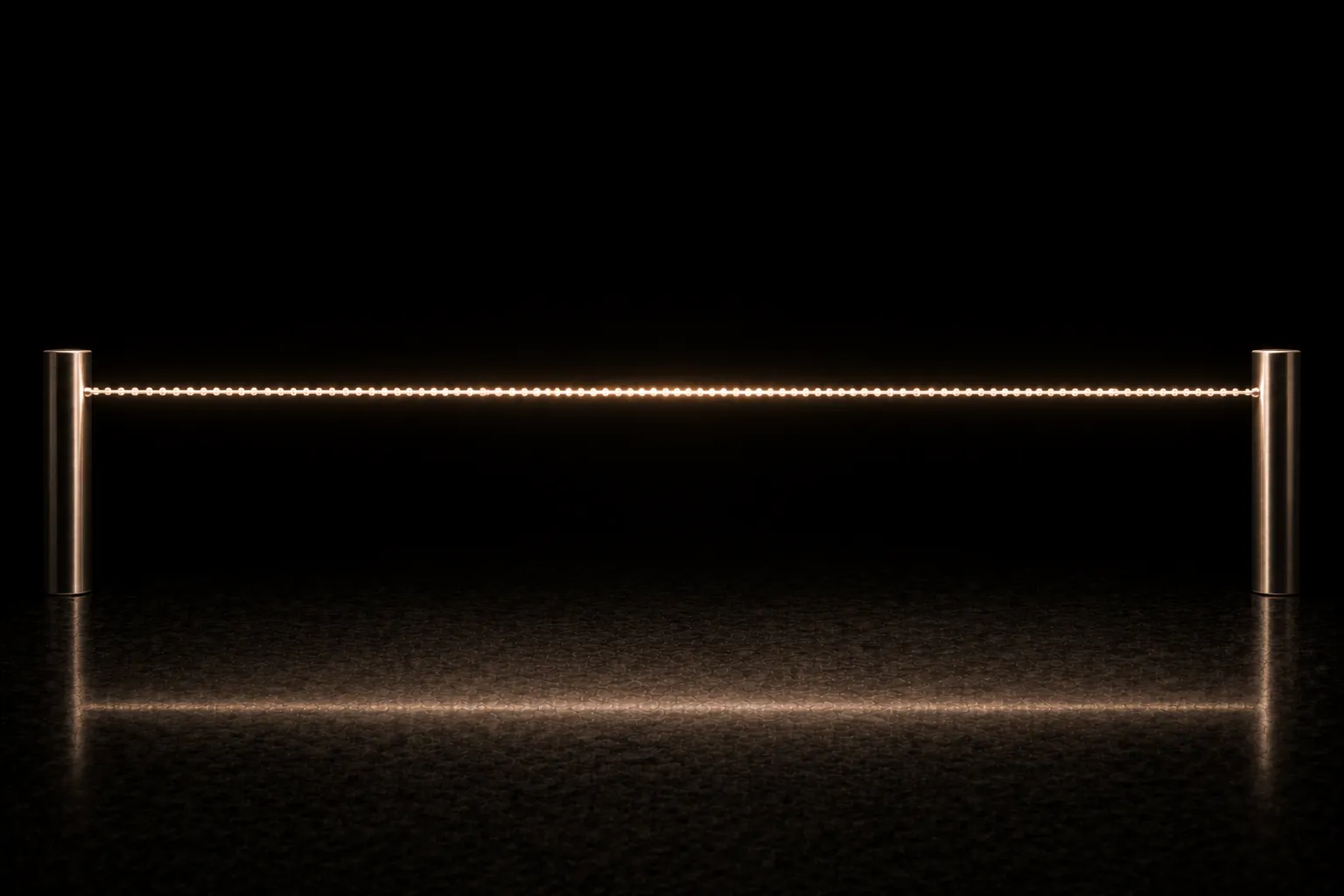 A taut wire strung between two steel posts, carrying an unbroken procession of hundreds of tiny bright beads all travelling the same way.