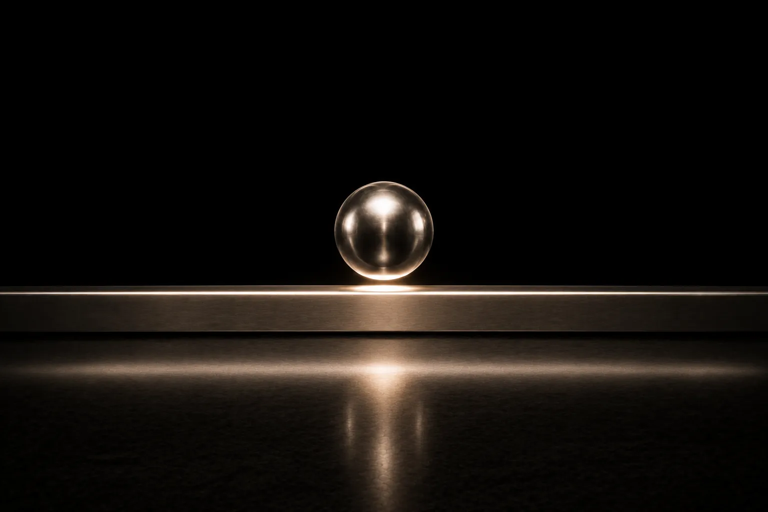 A polished sphere hovering a finger's width above a long, dead-level steel rail that runs straight and unbent on both sides of it.