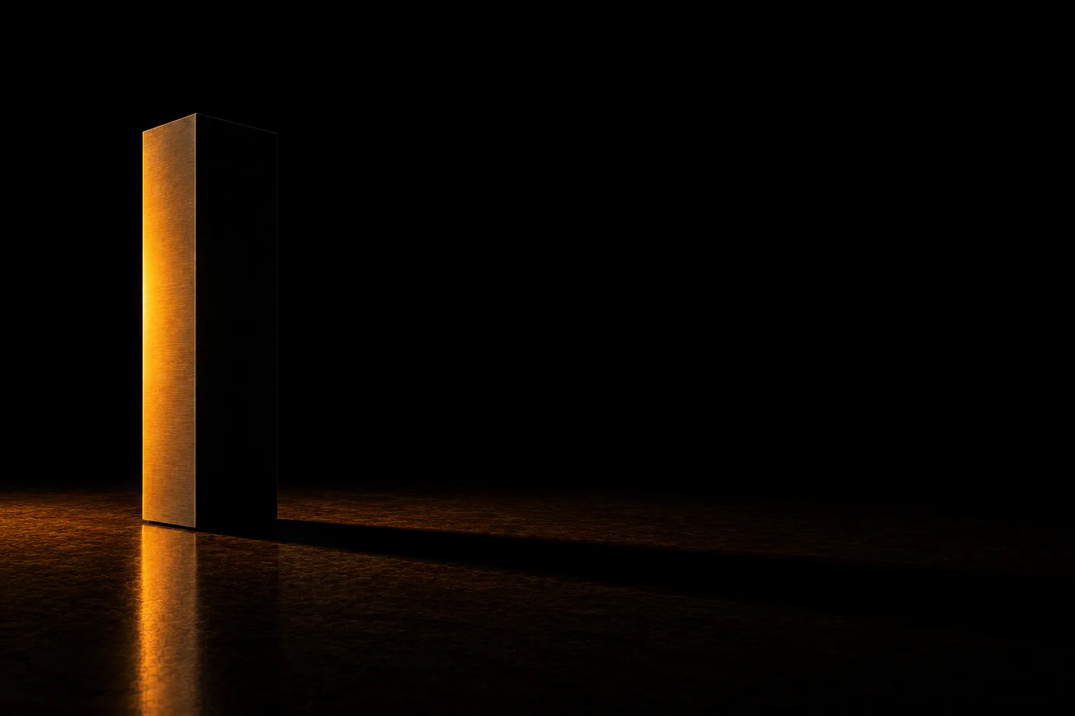 A steel column lit warmly from one side only, throwing a long hard shadow across the empty half of the floor.